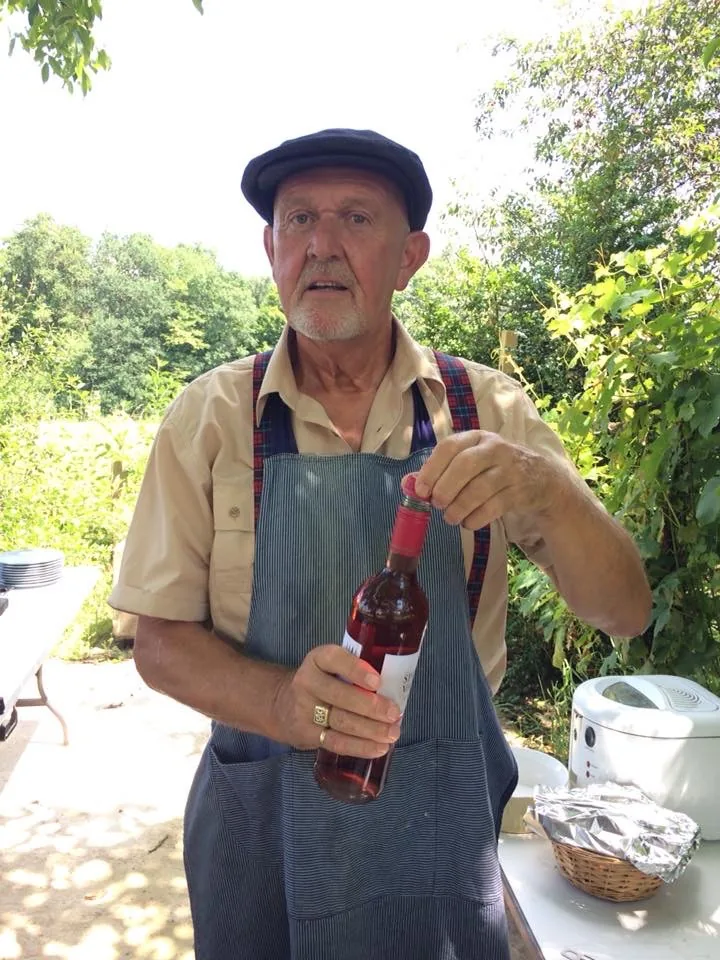 Een fles rosé wordt geopend in de tuin